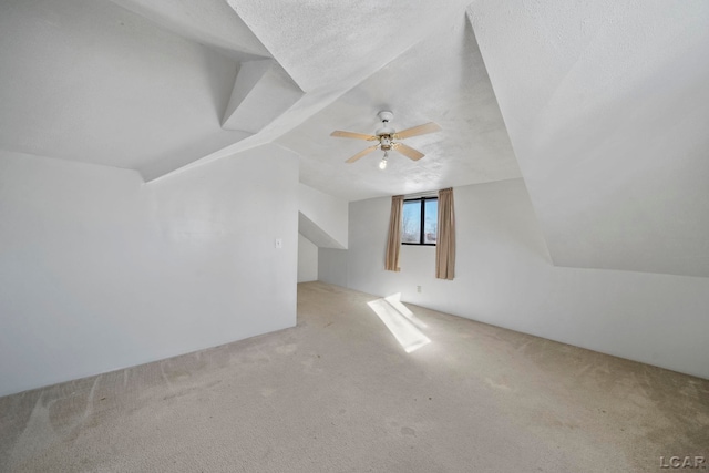 bonus room with carpet floors, a textured ceiling, and vaulted ceiling