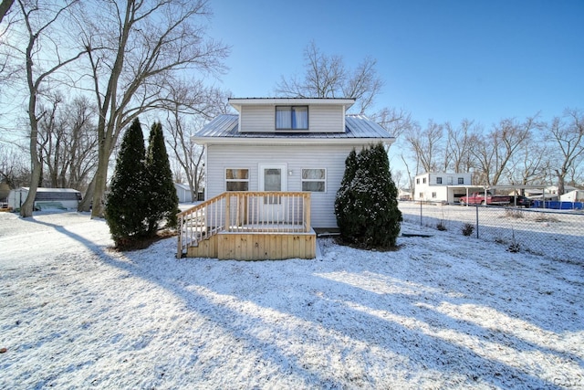 bungalow featuring metal roof and fence