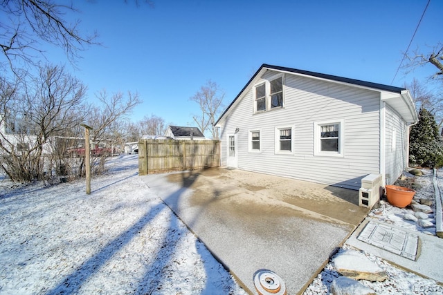 rear view of property featuring fence and driveway