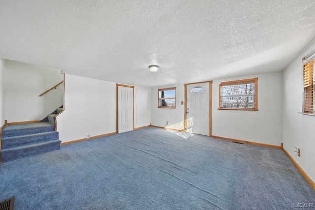 below grade area featuring stairs, baseboards, visible vents, and carpet floors