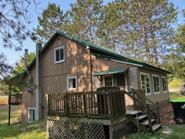 rear view of house featuring a deck and a chimney