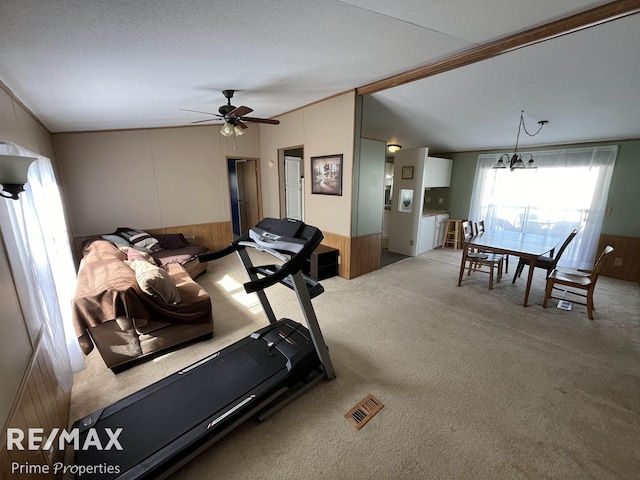 workout area featuring visible vents, a wainscoted wall, carpet, wood walls, and lofted ceiling