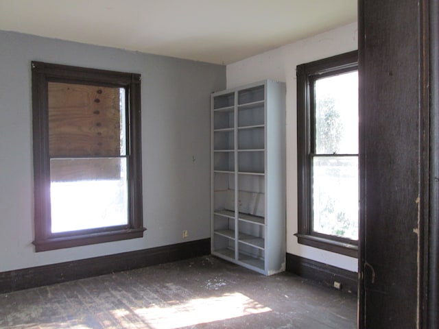 spare room with a wealth of natural light and baseboards