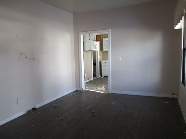 empty room with baseboards and hardwood / wood-style floors