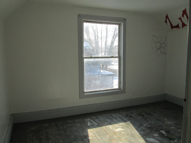 unfurnished room with baseboards and wood-type flooring