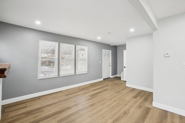 unfurnished room with recessed lighting, baseboards, and wood finished floors