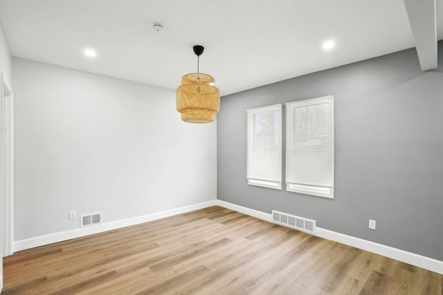 empty room with visible vents, baseboards, and wood finished floors