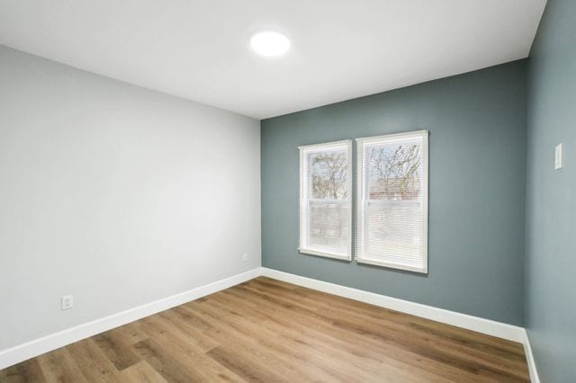 unfurnished room featuring baseboards and wood finished floors