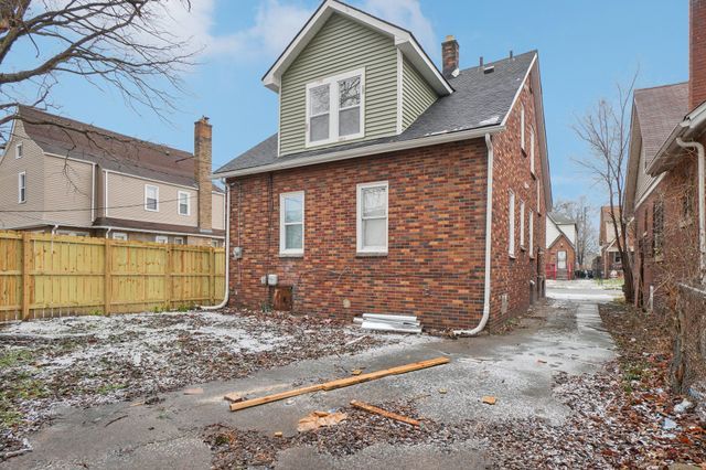 back of house with brick siding, a chimney, and fence