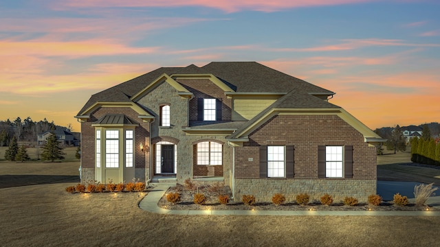 view of front of house featuring brick siding and a shingled roof