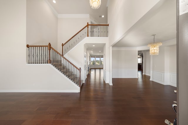 foyer entrance featuring an inviting chandelier, stairway, and wood finished floors