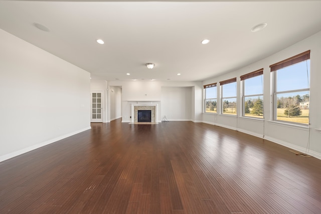 unfurnished living room featuring recessed lighting, baseboards, and dark wood finished floors