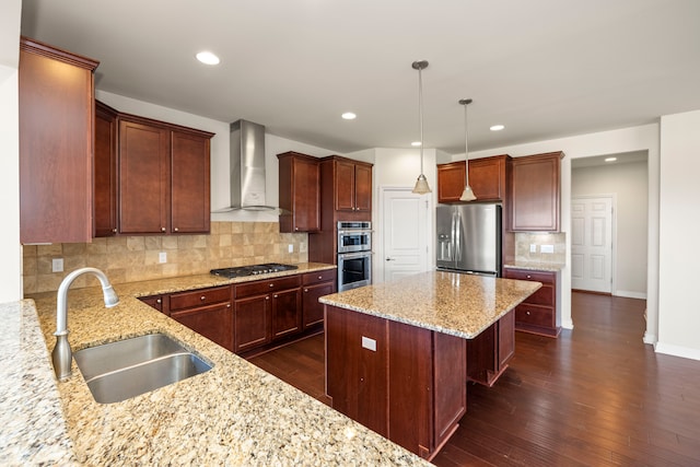 kitchen featuring dark wood-style floors, a kitchen island, a sink, appliances with stainless steel finishes, and wall chimney exhaust hood