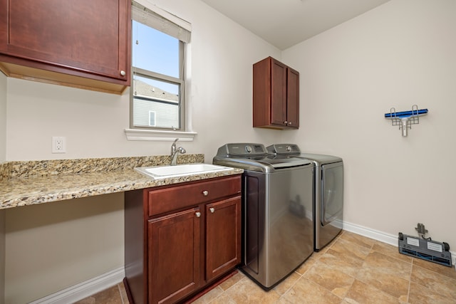 laundry area with washer and clothes dryer, cabinet space, baseboards, and a sink