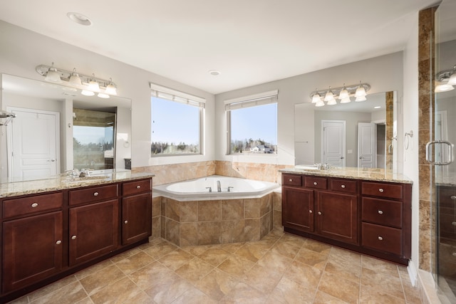 full bath with two vanities, a shower stall, a bath, and a sink