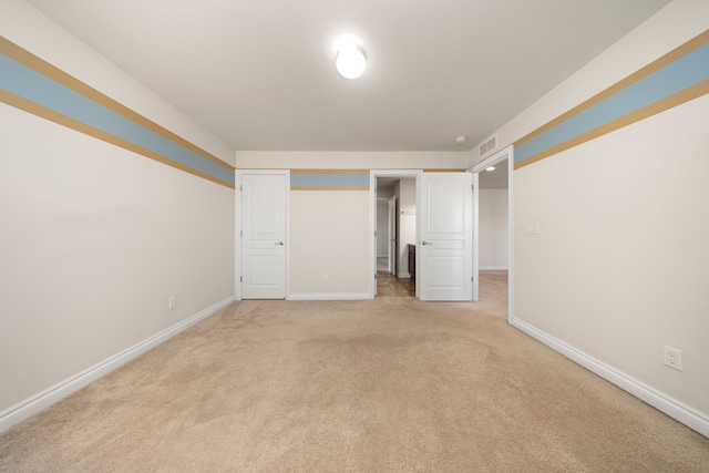 unfurnished bedroom featuring baseboards, visible vents, and light carpet