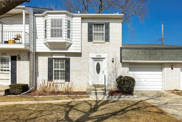 view of front of home with brick siding, a shingled roof, a balcony, concrete driveway, and an attached garage