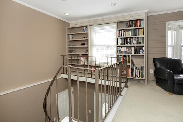 interior space featuring carpet flooring, an upstairs landing, and crown molding