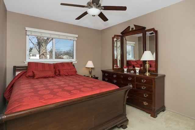 bedroom featuring light colored carpet, ceiling fan, and baseboards