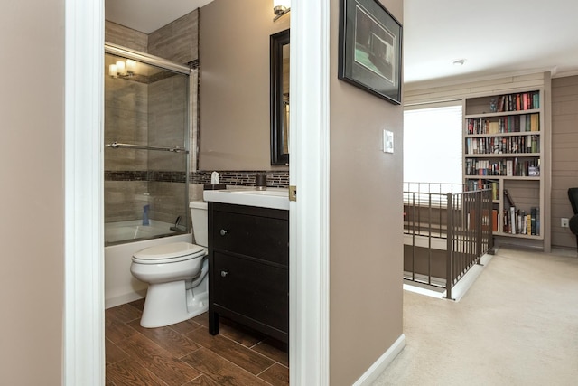 bathroom featuring shower / bath combination with glass door, vanity, tasteful backsplash, toilet, and wood finished floors
