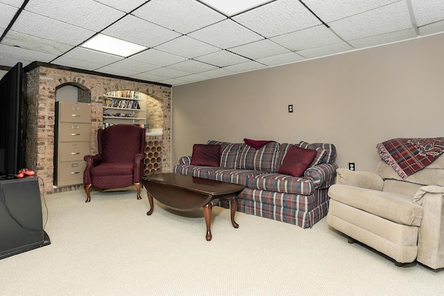living area featuring a drop ceiling and carpet