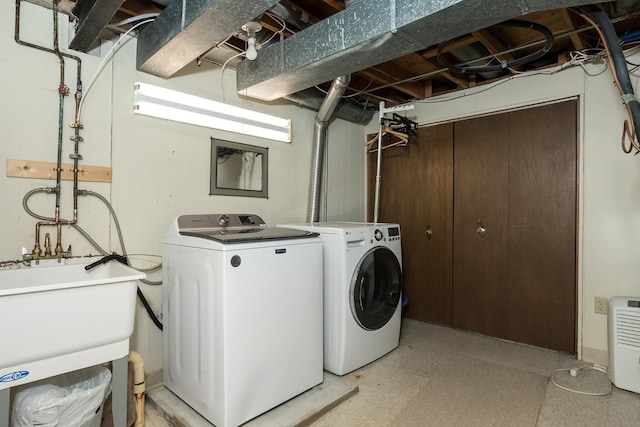 washroom with washer and clothes dryer, light floors, laundry area, and a sink