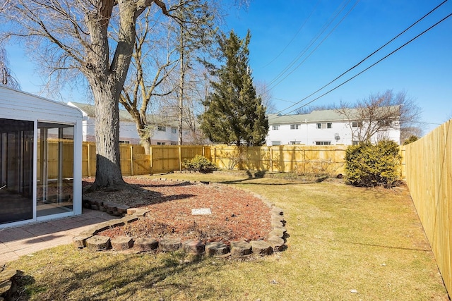 view of yard featuring a sunroom and a fenced backyard