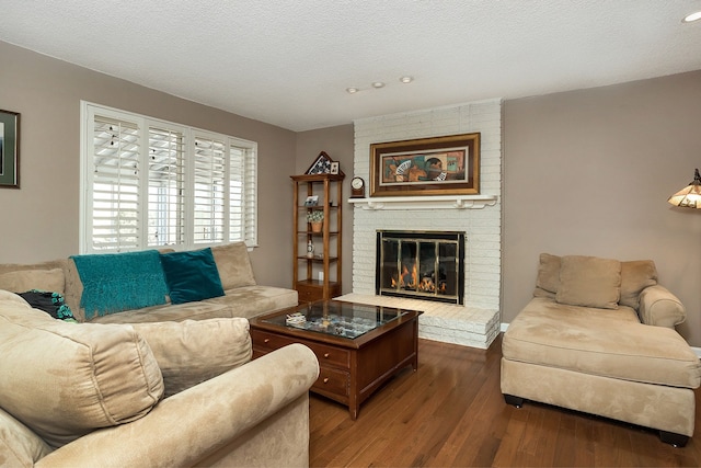 living room with a fireplace, a textured ceiling, hardwood / wood-style flooring, and recessed lighting