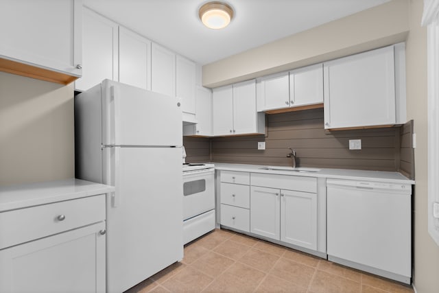 kitchen featuring under cabinet range hood, light countertops, white cabinets, white appliances, and a sink