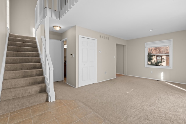 interior space with visible vents, stairway, and carpet floors