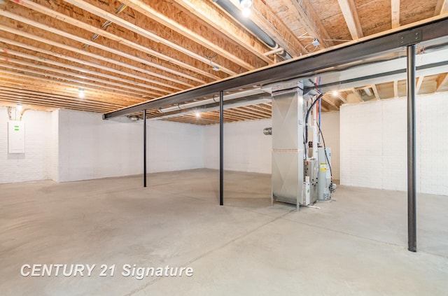 unfinished basement with electric panel, heating unit, and water heater