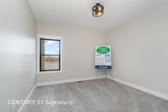 carpeted spare room with baseboards