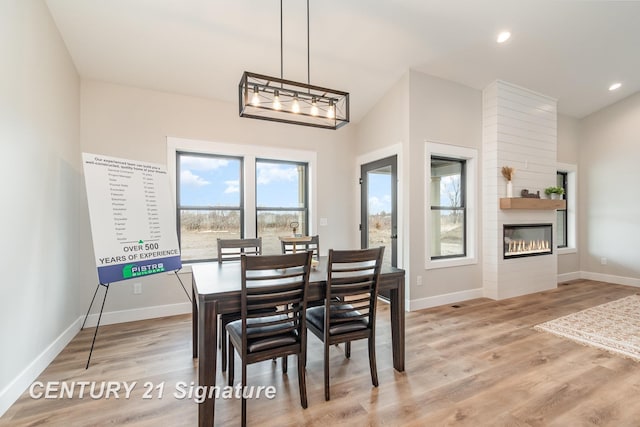 2289 Holly Ridge Ln, Bay City, MI 48706 - dining space with light wood finished floors, baseboards, a large fireplace, and recessed lighting