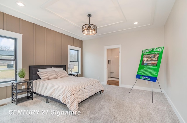 carpeted bedroom with baseboards, a chandelier, a tray ceiling, recessed lighting, and ensuite bathroom