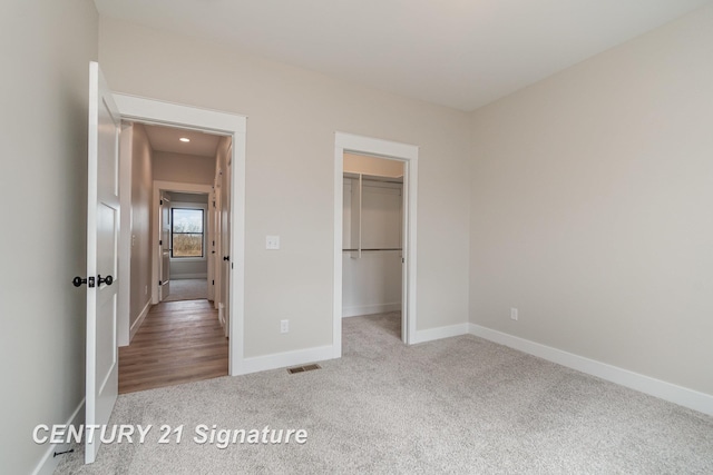 2289 Holly Ridge Ln, Bay City, MI 48706 - unfurnished bedroom featuring carpet flooring, baseboards, a walk in closet, and a closet