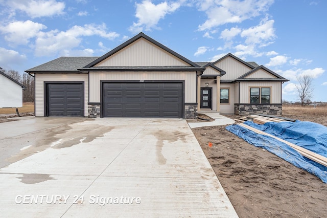 view of front of house with concrete driveway, an attached garage, stone siding, and a shingled roof