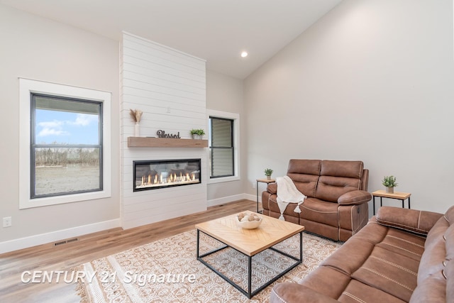 2289 Holly Ridge Ln, Bay City, MI 48706 - living room featuring wood finished floors, baseboards, a fireplace, recessed lighting, and high vaulted ceiling