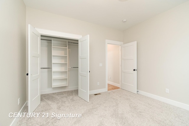 unfurnished bedroom with a closet, baseboards, visible vents, and carpet floors