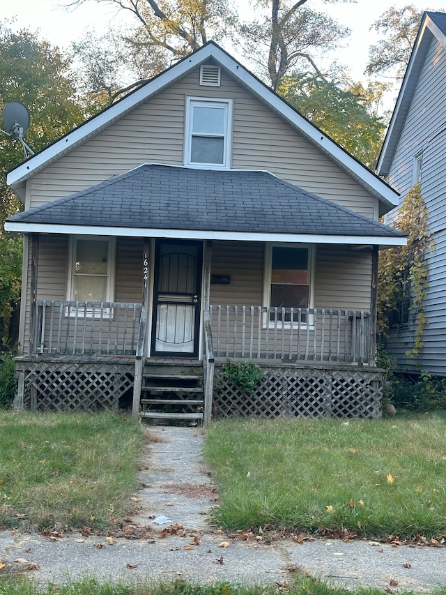 bungalow-style home featuring roof with shingles and covered porch