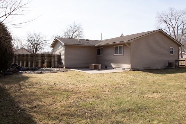 rear view of property featuring a patio, a lawn, central AC, and fence