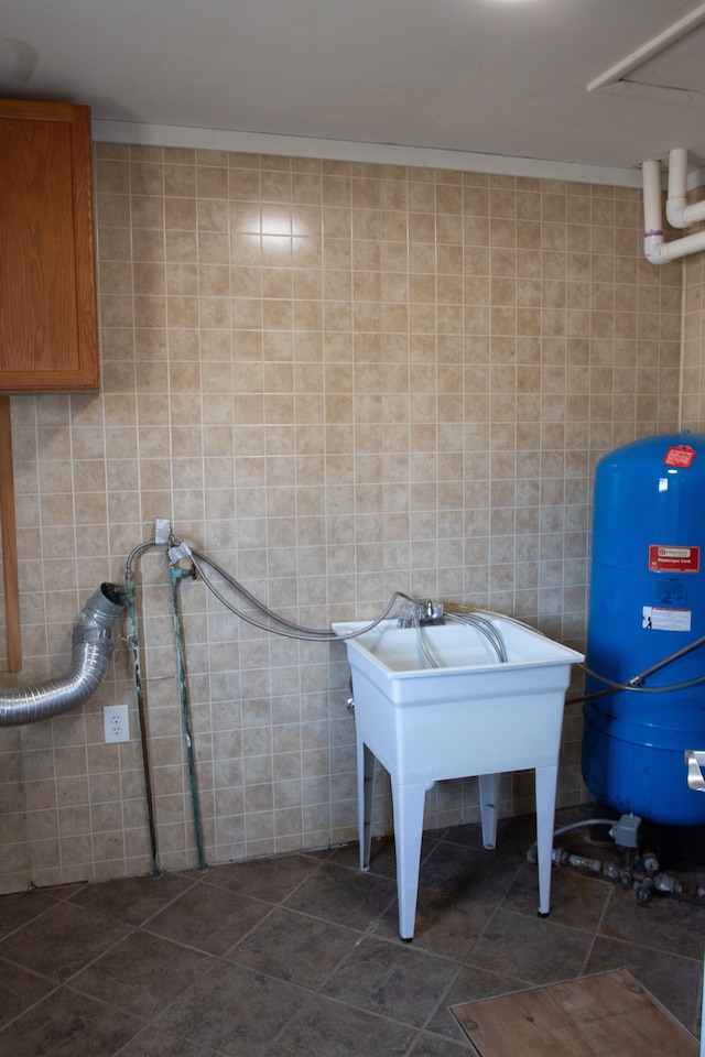 bathroom with a sink, tile walls, and tile patterned flooring