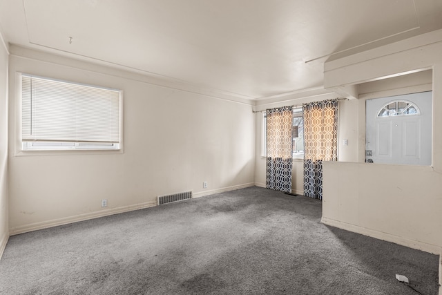 unfurnished room featuring visible vents, carpet floors, and baseboards