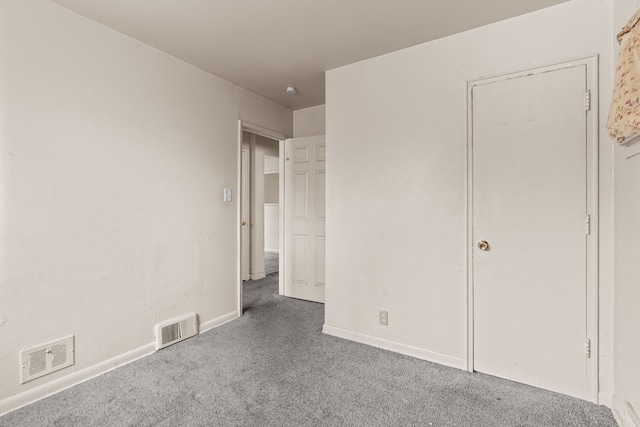 unfurnished bedroom with carpet, visible vents, and baseboards