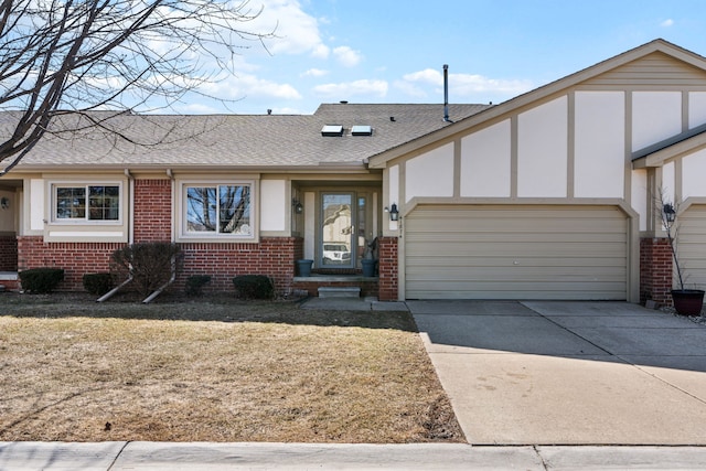 view of front of home with driveway, a front lawn, roof with shingles, an attached garage, and brick siding