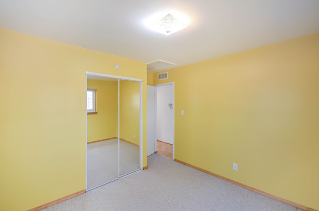 unfurnished bedroom featuring a closet, visible vents, baseboards, and carpet