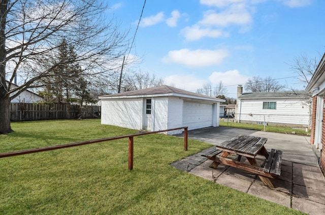 view of yard featuring a detached garage, an outdoor structure, and fence