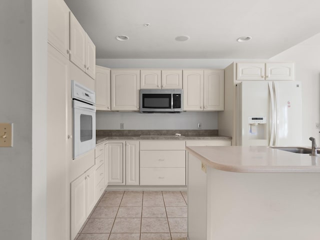 kitchen with light tile patterned floors, recessed lighting, white appliances, and a sink