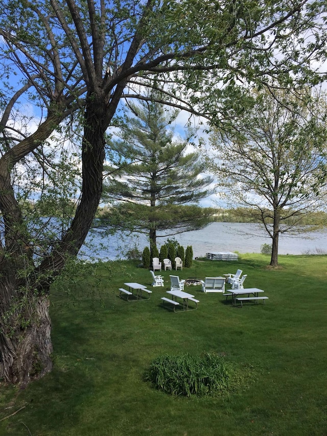 surrounding community featuring a water view and a lawn