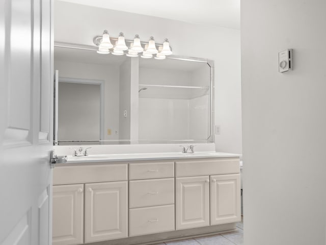 full bath with tile patterned flooring, double vanity, and a sink