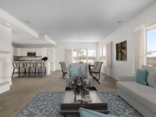 living area featuring baseboards, carpet floors, and a chandelier